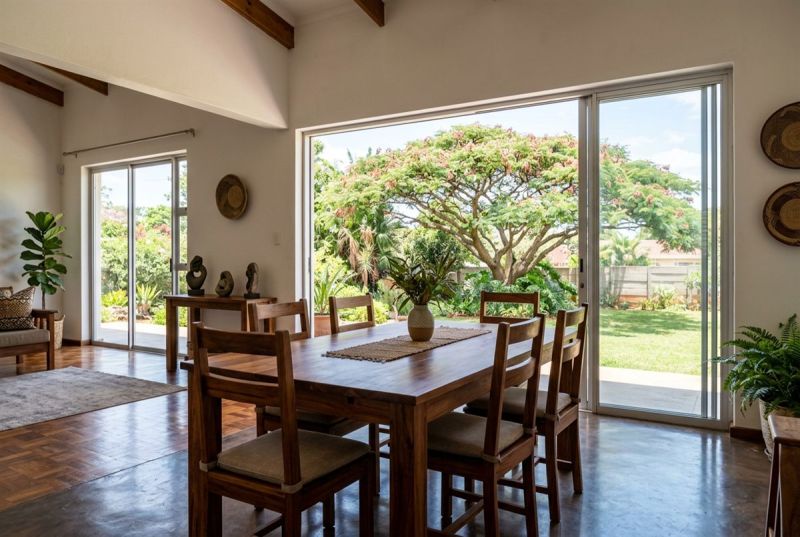Hardwood dining table with six chairs by glass doors