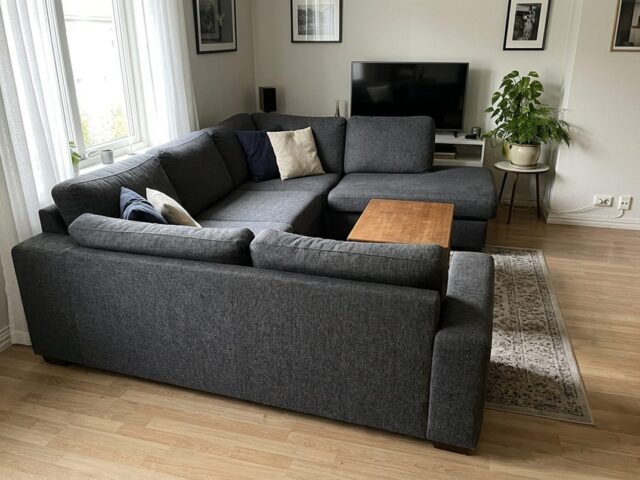 Charcoal L-shaped corner couch in a living room with a wooden coffee table